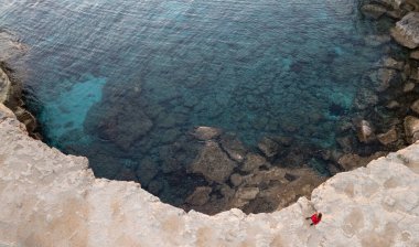 Cape Greko ya da Cape Greco deniz mağaraları Ayia Napa Kıbrıs manzarası. Turistler etrafı geziyor..