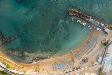 Tropikal kumsalın insansız hava aracı antenleri. Plaj şemsiyeleri insanlar yüzüyor ve dinleniyor. Yaz tatilleri. Ayia triada, Kıbrıs Protaras
