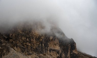 Bulutlu sisli gökyüzü dağ zirveleri sabah sisle kaplanır. Dolomite kayalık dağları İtalya.