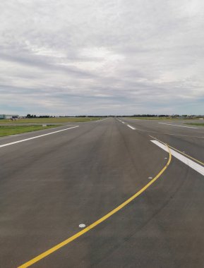 Gökyüzüne karşı havaalanı pistinin yüzey seviyesi. Havaalanı altyapısı bulutlu gökyüzü