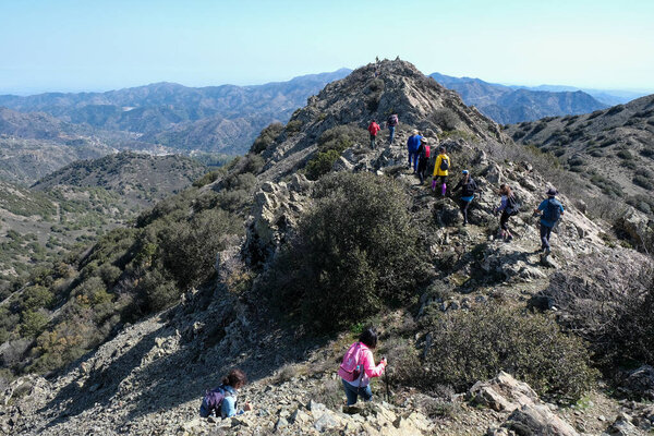 Троодос, Кипр 5 марта 2023 года: группа туристов, путешествующих по природной тропе на вершине скалы в районе Троодос Кипр. Здоровый образ жизни, люди активные на открытом воздухе.