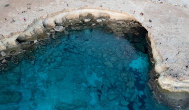 Cape Greko ya da Cape Greco deniz mağaraları Ayia Napa Kıbrıs manzarası. Turistler etrafı geziyor..