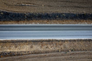 Kırsal kesimdeki boş yolların insansız hava aracı antenleri. Kuru toprak