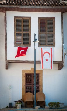 Geleneksel bir eski binada Türk ve Noth Kıbrıs bayrakları görülüyor. Lefkoşe Kıbrıs