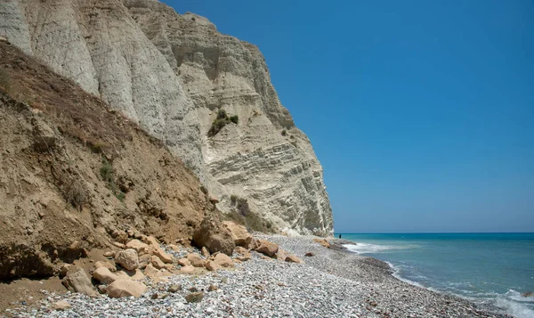 落基悬崖在海里 一个有岩石海岸线的又长又窄的海滩 Limassol塞浦路斯 图库照片
