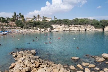 Protaras, Kıbrıs, Ekim 12023: İnsanlar güneşleniyor ve denizde yüzüyorlar. Tatildeki insanlar. Kıbrıs Rum Kesimi Malama plajı