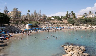 Protaras, Kıbrıs, Ekim 12023: İnsanlar güneşleniyor ve denizde yüzüyorlar. Tatildeki insanlar. Kıbrıs Rum Kesimi Malama plajı