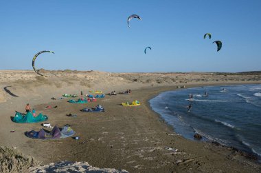 Limasol, Kıbrıs, 10 Ekim 2020: Açık mavi gökyüzü ile güneşli bir günde uçurtma sörfü yapan bir grup Kite sörfçüsü. Akrotiri Sahili Kirişi