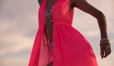 Kırmızı elbiseli, modellik ve poz veren tanınmamış Afrikalı model kadın.