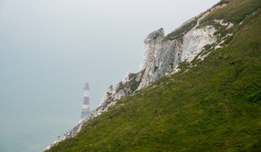 Beyaz tebeşir uçurumunun kenarındaki deniz feneri. Okyanusta güvenlik uyarısı.