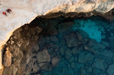 Cape Greko ya da Cape Greco deniz mağaraları Ayia Napa Kıbrıs manzarası. Turistler etrafı geziyor..