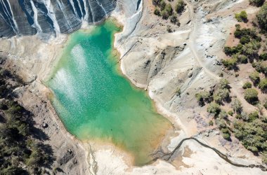 Terk edilmiş bir bakır madeninin zehirli gölünün insansız hava manzarası. Çevre kirliliği kavramı. Kıbrıs Troodos