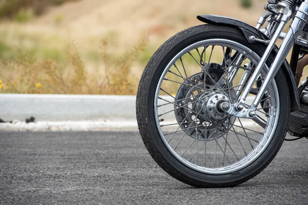 Motosikletin ön tekeri yakın çekimde, sokakta. Bisiklet sürmek. Motosikletin ön tekerleğini kapat..