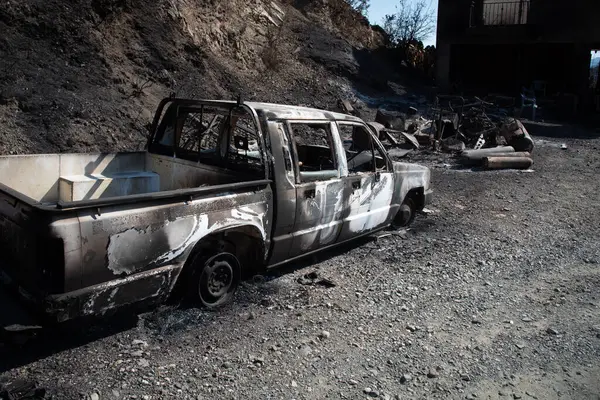 Destroyed burnt car and property after fire.