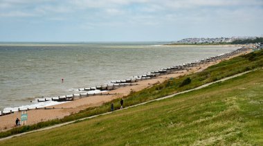 Halka açık bir sahil yolunda yürüyen tanınmamış insanlar. Aktif insanlar. Sağlıklı bir yaşam tarzı. Whitstable Birleşik Krallık