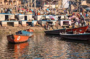 Varanasi, Hindistan, 13 Mart 2017, sabah kutsal Ganj nehrinin Iat nehir kıyısındaki tahta tekneler. Hintliler banyo yapıyor.
