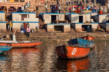 Varanasi, Hindistan, 13 Mart 2017, sabah kutsal Ganj nehrinin Iat nehir kıyısındaki tahta tekneler. Hintliler banyo yapıyor.