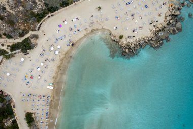 Muhteşem kumlu tatil plajının en üst görüntüsü. Konnos Körfezi 'ndeki plaj insanları dinleniyor ve yaz tatilinin tadını çıkarıyor. Kıbrıs Protaras