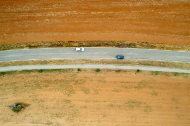 Kırsal kesimde, araba kullanan boş bir yolda insansız hava aracı. Kuru toprak
