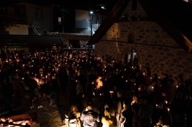 Lefkoşe, Kıbrıs, 23 Nisan 2022: Ortodoks Paskalya Kutsal Cumartesisi kutlamaları sırasında elinde mum tutan ve Hıristiyan kilisesi önünde dua eden bir kalabalık