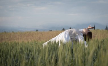 Genç dansçı kadın dışarıda dans ediyor. Çayır tarlasında modern dans gösterisi. Tasasız ve doğadaki özgürlük