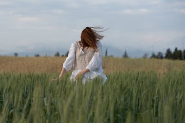 Genç dansçı kadın dışarıda dans ediyor. Çayır tarlasında modern dans gösterisi. Tasasız ve doğadaki özgürlük