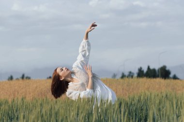 Genç dansçı kadın dışarıda dans ediyor. Çayır tarlasında modern dans gösterisi. Tasasız ve doğadaki özgürlük