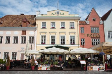 Tallinn, Estonya, 20 Temmuz 2024: Tallinn eski şehir merkezi renkli binalar, kahve dükkanları, restoranlar ve dinlenen insanlar. Bulutlu yaz günü