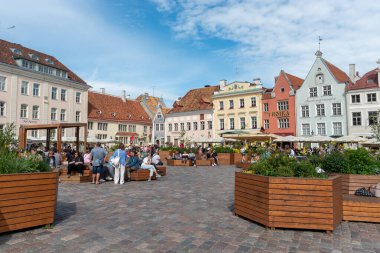 Tallinn, Estonya, 20 Temmuz 2024: Tallinn eski şehir merkezi renkli binalar, kahve dükkanları, restoranlar ve dinlenen insanlar. Bulutlu yaz günü