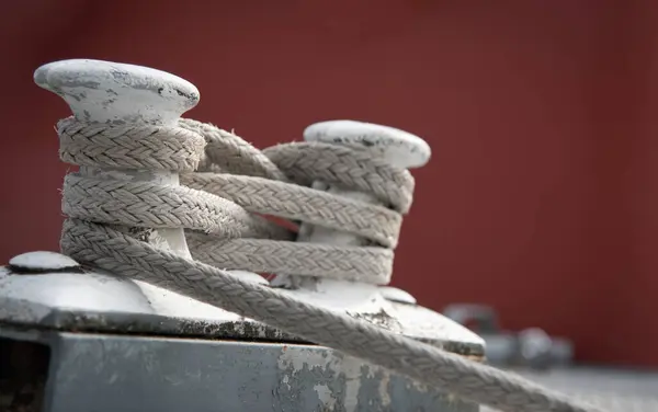 stock image Twisted ship mooring strong rope for securing fishing boats tied on a metal pole. Security, safety fasten