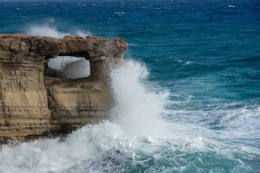 Dalgalar kayalık kıyılara çarpıyor. Rüzgarlı hava, kayaların üzerinde fren yapan güçlü deniz dalgaları. Cape Greko Ayia Napa Kıbrıs