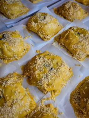 Geleneksel çiğ, ev yapımı, Kıbrıs usulü paskalya peynirli hamur işleri pişirilmeye hazır bir masada sallanıyor..