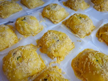 Geleneksel çiğ, ev yapımı, Kıbrıs usulü paskalya peynirli hamur işleri pişirilmeye hazır bir masada sallanıyor..