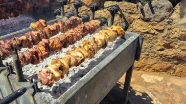 Pork lamb and chicken meat cooked traditionally on a charcoal bbq grill with charcoal. Cyprus traditional souvla food on barbecue. clipart