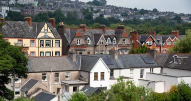Geleneksel üçgen çatıları olan renkli İrlanda evleri ve daireleri. Mantar, İrlanda