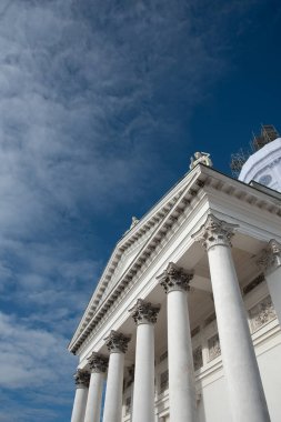 Low angle view of details of the neoclassical style architecture of the cathedral of Helsinki against cloudy sky. clipart