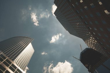 Şehrin bulutlu gökyüzüne uzanan modern gökdelenlerin alçak açılı görüntüsü