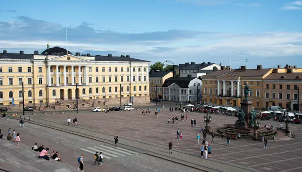 stock image Helsinki, Finland, July 18 2024: Tourists enjoying sunny summer day at the senate square in helsinki, finland, with the government palace in the background