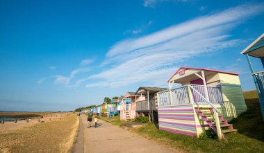 Multi-coloured holiday wooden beach huts facing the ocean on the beach of Tankerton Whitstable coast, Kent district England. clipart