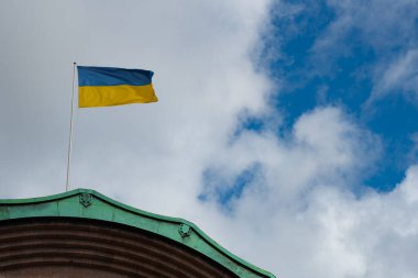 Rüzgarda dalgalanan Ukrayna bayrağı, bulutlu bir gökyüzü arka planında