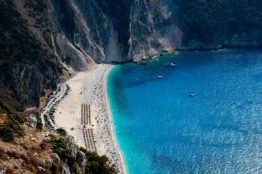 Sahilde turistlerle kristal berrak su manzaralı tropik bir sahil manzarası var. Myrtos ünlü sahil iyonları denizi Kefalonya Yunanistan.