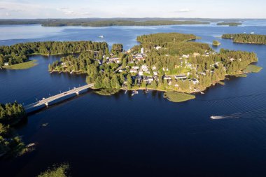 Rono Adası 'nın ve yeşil ağaçlar ve tatil kulübeleriyle kaplı sayısız küçük adanın insansız hava aracı görüntüsü. Köprü adayı anakaraya bağlıyor. Kallavesi Gölü Kuopio Finlandiya, Kuzey Savonia Avrupa