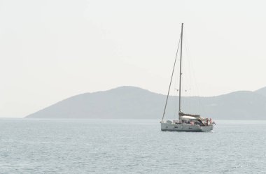 Yelkenli ve direkli yelkenli sisli bir günde sakin bir denizde seyrediyor, Kefalonia Yunan adası, iyon denizi Yunanistan