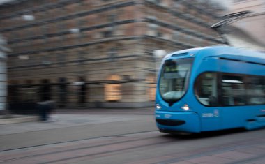 Şehir caddesinden geçen modern mavi tramvay hız üzerine vurgu yapıyor. Zagrep 'in Hırvat toplu taşımacılığı