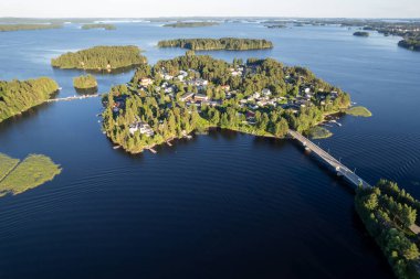 Rono Adası 'nın ve yeşil ağaçlar ve tatil kulübeleriyle kaplı sayısız küçük adanın insansız hava aracı görüntüsü. Köprü adayı anakaraya bağlıyor. Kallavesi Gölü Kuopio Finlandiya, Kuzey Savonia Avrupa