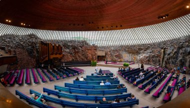 Helsinki, Finlandiya, 19 Temmuz 2024: Finlandiya 'nın başkenti Helsinki' de doğrudan kayaya oyulmuş temppeliaukio kilisesinin içindeki insanlar