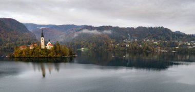 Mary Hac Kilisesi 'nin sakin gölü yansıttığı varsayımı kanıyordu. Dağlar ve renkli sonbahar yapraklarıyla çevrelenmişti.