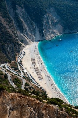Sahilde turistlerle kristal berrak su manzaralı tropik bir sahil manzarası var. Myrtos ünlü sahil iyonları denizi Kefalonya Yunanistan.