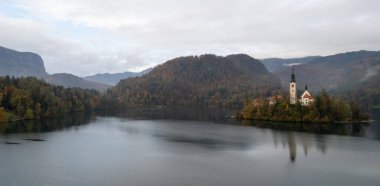 Mary Hac Kilisesi 'nin sakin gölü yansıttığı varsayımı kanıyordu. Dağlar ve renkli sonbahar yapraklarıyla çevrelenmişti.