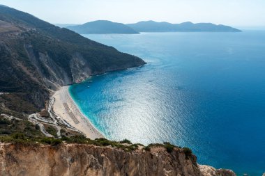 Sahilde turistlerle kristal berrak su manzaralı tropik bir sahil manzarası var. Myrtos ünlü sahil iyonları denizi Kefalonya Yunanistan.